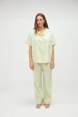Camisa de manga corta de algodón con diseño a rayas en tonos amarillo y blanco, calce holgado, cuello solapa y bolsillo aplicado en el pecho.