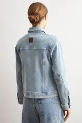 Chaqueta clásica de jean color celeste, con bolsillos frontales con solapa, cierre de botones metálicos y cuello camisero.