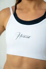 Top deportivo blanco con doble tela y tirantes finos.