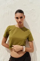 Camiseta cropped color amarillo, de corte slim fit, cuello redondo y manga corta.