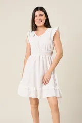 Vestido corto blanco con cuello en V, mangas cortas con volados, cintura elastizada y falda con volados.