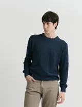 Sweater de punto con escote redondo, confeccionado en algodón con textura de punto fantasía en cuerpo y mangas, y terminaciones en punto canalé en cuello y puños.