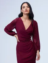 Vestido azul de RM Richards en seda fría, con escote en V cruzado, cintura drapeada, mangas largas de gasa y aplique de botones en el lateral.