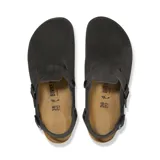 Zueco de gamuza color negro con correa ajustable en el talón, hebillas metálicas negras, plantilla de corcho y suela de goma antideslizante.