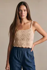 Top de algodón con diseño de tejido crochet y calce al cuerpo, con breteles finos y ruedo con terminación ondulada.
