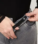 Pantalón de jean de corte recto y tiro medio, color gris con acabado lavado y aplicaciones de brillos distribuidas en las piernas. Cuenta con diseño de cinco bolsillos, cierre frontal con botón y costuras reforzadas.
