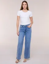 Jean de denim azul de corte wide leg, tiro alto con cintura elastizada en la parte trasera, cinco bolsillos y cierre frontal con botón y cremallera.
