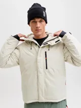 Campera técnica impermeable y cortaviento con capucha ajustable, diseñada para condiciones de frío y nieve. Cuenta con cierre frontal, bolsillos con cierre, ventilación bajo los brazos y ajustes en puños.