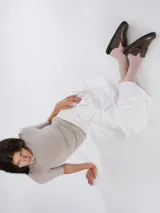 Zuecos de cuero color suela con diseño de punta redonda y ajuste mediante una tira con hebilla metálica en el empeine. Presentan una suela plana de goma negra y plantilla interior con logo grabado.