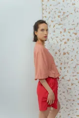 Campera estilo bomber color salmón, confeccionada en tela texturizada, con cierre frontal y bolsillos delanteros.