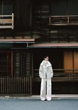 Parka de corte recto color blanco, confeccionada en mezcla de lana, con cuello embudo, bolsillos de solapa laterales, manga larga con trabillas y cierre delantero con botones.