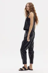 Pantalón negro de lino metalizado, corte recto y tiro medio.