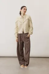 Pantalón de corte ancho y holgado, de color negro, con diseño estructurado y cinturón ajustable integrado en la cintura.