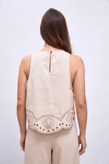 Blusa color beige con bordados de palmeras y conchas marinas en color marrón.