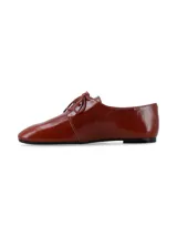 Zapato tipo oxford de cuero charolado color cognac, con cierre de cordones y suela plana.