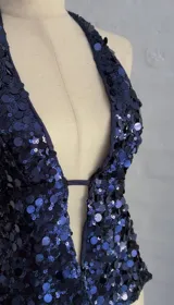 Top azul con lentejuelas, escote halter y espalda descubierta.