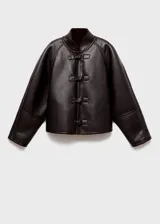 Chaqueta reversible de corte recto y diseño oversize, confeccionada en efecto cuero con interior de borreguito. Presenta cuello alto, cierre frontal con botones y mangas largas.