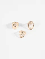 Set de tres anillos dorados con acabado metálico brillante. El conjunto incluye un anillo de diseño sólido y redondeado, un anillo con forma de eslabón ovalado y un anillo con diseño de banda cruzada.