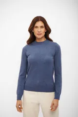 Sweater de punto fino color azul melange, con cuello media polera y mangas largas. Presenta terminaciones acanaladas en puños y ruedo.