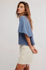 Remera de jersey de algodón blanca con silueta murciélago, escote barco y mangas dolman muy anchas de corte recto y holgado.