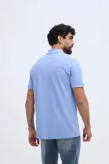 Remera polo verde militar de algodón pima, con cuello y puños acanalados, cierre frontal de tres botones y pequeño bordado de ave en el pecho.