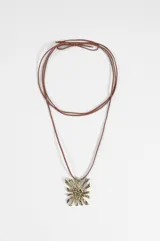 Collar de cordón marrón con dije metálico en forma de sol con la inscripción 'YO RU GUA' en el centro.