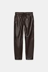 Pantalón de tiro alto confeccionado en material efecto piel, con cintura elástica ajustable mediante cordones, bolsillos delanteros y bolsillos de plastrón en la parte trasera.