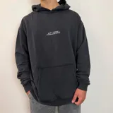 Canguro oversize color beige con capucha y estampado gráfico en la espalda que incluye un esqueleto de pez y texto descriptivo.