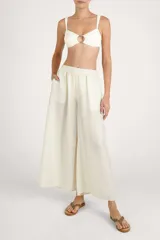 Pantalón fluido color crema, de corte ancho y relajado, con cintura elástica fruncida.
