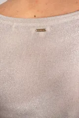 Remera color champagne de lurex con escote en V y mangas cortas. Tejido de punto acanalado.