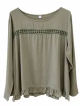 Blusa verde militar de manga larga con cuello redondo y detalles bordados en el pecho. Cuenta con un volante fruncido en el borde inferior.