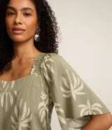 Blusa verde militar con estampado de cocoteros en tono claro, de mangas corta tipo godê y escote cuadrado con detalles fruncidos.