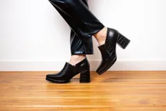 Botines negros de cuero con plataforma y taco cuadrado con textura de reptil.