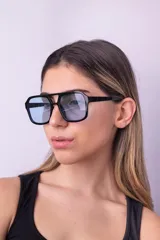 Lentes de sol con armazón de policarbonato negro y cristales tintados en tono ámbar, con diseño de estilo retro y protección UV400.
