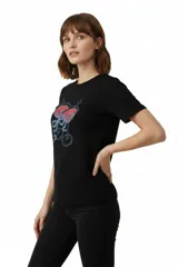 Remera de algodón color beige con estampado frontal de un corazón rosado que contiene un moño. Tiene cuello redondo y mangas cortas.