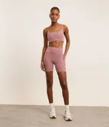 Top deportivo femenino color morado oscuro, de corte recto y ajustado, con escote cuadrado y breteles finos ajustables.