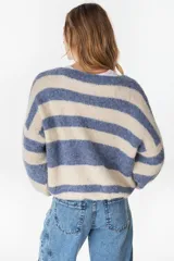 Cardigan tejido de punto a rayas horizontales en tonos crudo y beige, de manga larga y diseño holgado.