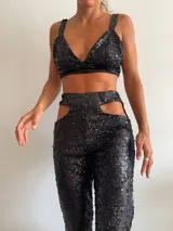 Top de bikini negro con lentejuelas, breteles anchos y espalda descubierta.