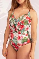 Malla entera con estampado floral en tonos rojos, verdes y azules sobre fondo blanco. Escote en V y tirantes finos cruzados en la espalda.