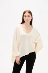 Poncho negro de tejido de punto con escote en V, diseño asimétrico y corte holgado.