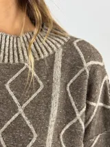 Sweater de lana color bordó con cuello alto y diseño de rombos y líneas verticales en rojo. Tiene puños y dobladillo acanalados.