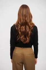 Saco de punto negro con cuello redondo, cierre frontal de botones y detalles brillantes dispersos.