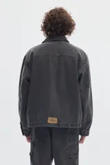 Campera de denim color gris oscuro con lavado washed, cierre metálico frontal y bolsillos delanteros, de diseño clásico.