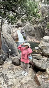 Buzo oversized de punto color tostado con diseño gráfico frontal en azul inspirado en una estampilla con una sirena y el texto 'Taormina'. Presenta tajos laterales, cuello redondo y terminaciones en contraste de color azul.