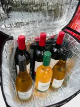 Bolso térmico cuadrado de gran capacidad, color negro con estampado en blanco de sirenas y motivos marinos. Posee asas de mano y una correa ajustable estampada con el monograma de la marca.