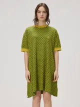 Vestido corto de algodón con estampa geométrica en tonos verde y amarillo, cuello redondo y mangas cortas con puños en color contrastante.