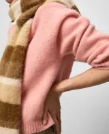 Sweater de punto color rosa, de corte corto con cuello redondo y mangas largas. Presenta acabados en canalé en cuello, puños y bajo. Confeccionado en una mezcla de lana merino y alpaca que ofrece una textura suave y abrigada.