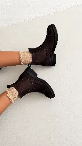 Botas tipo Chelsea de gamuza color marrón oscuro, con paneles elásticos laterales a tono, puntera redondeada y suela plana de goma negra.