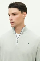 Buzo azul de felpa con medio cierre frontal, cuello alto y logo de goma en el pecho.