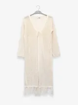 Cárdigan largo de algodón color crudo, tejido con punto abierto y detalles de flecos en el ruedo.